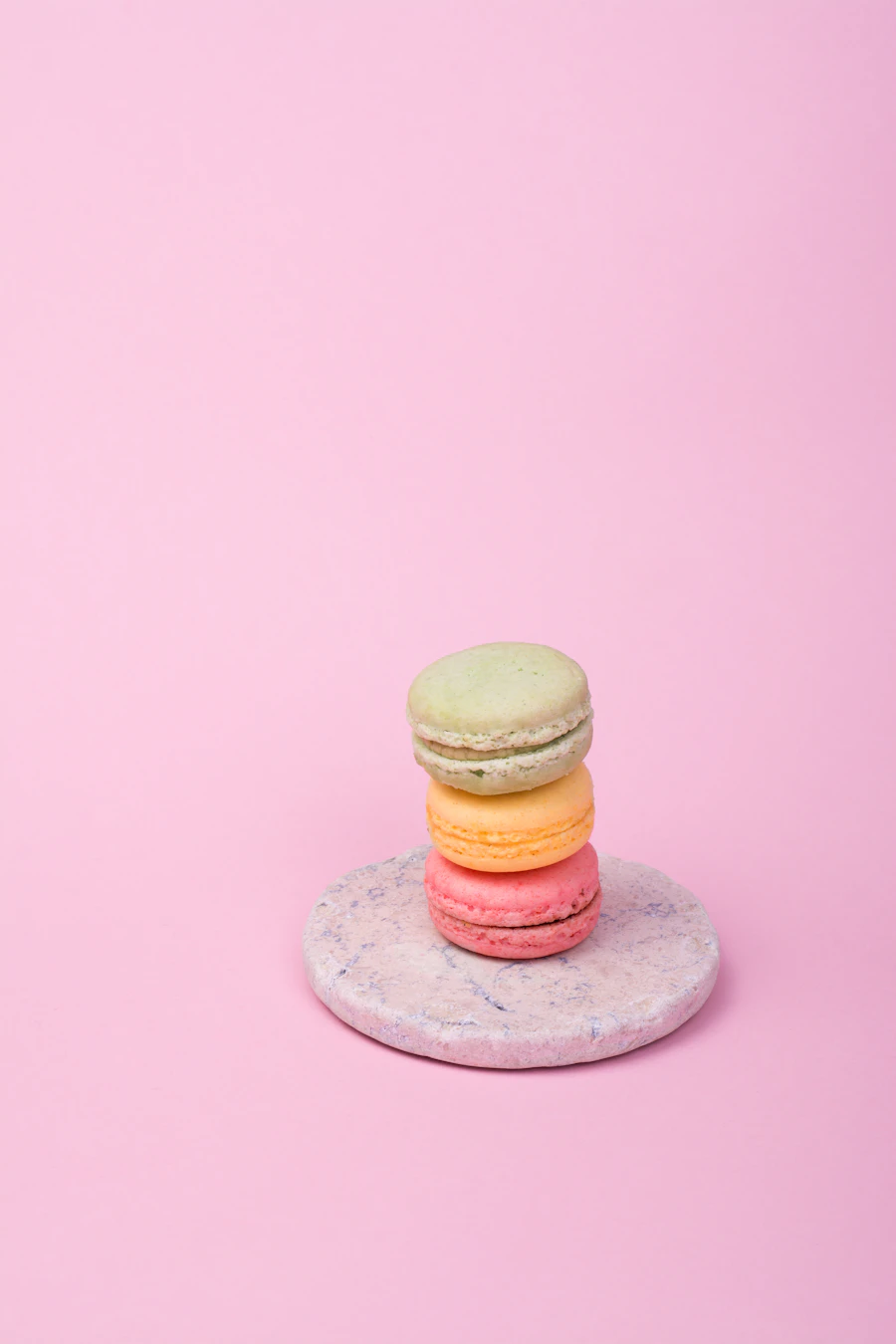 Pink macarons stacked on a pink plate