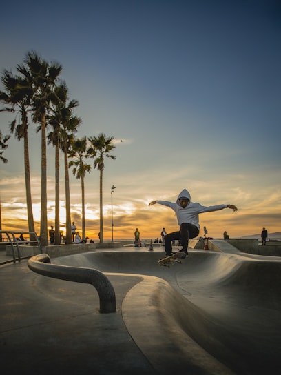 Urban skateboarder performing a trick on a city street in Granada at sunset.