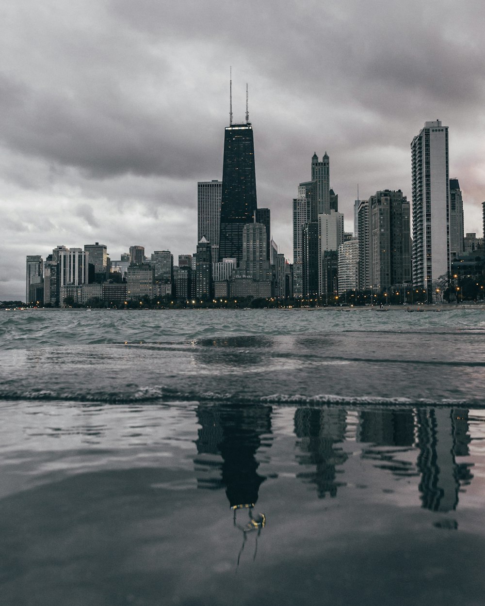 calmo specchio d'acqua vicino a edifici in cemento durante il giorno