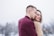 man hugging woman while standing on snowy weather