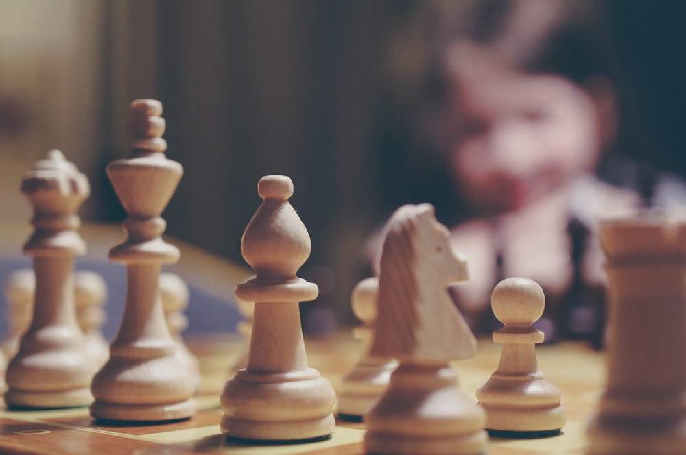 beige chess piece on board in selective focus photography