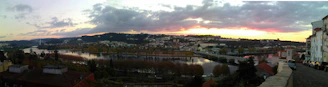 A panoramic view of Porto city at sunset with the Douro River and iconic bridges in purple hues.