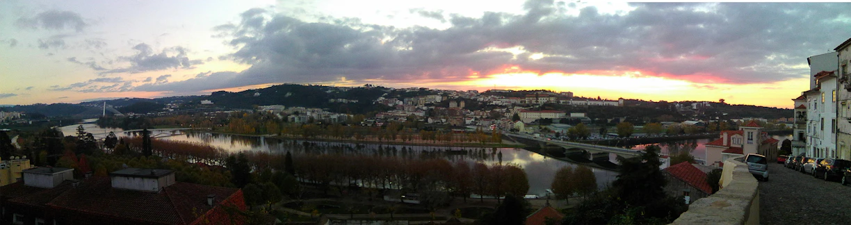 A panoramic view of Porto city at sunset with the Douro River and iconic bridges in purple hues.