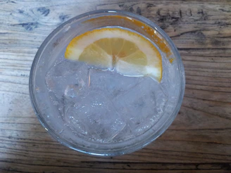 A close-up of a glass filled with freshly squeezed lemonade, condensation glistening on the outside.