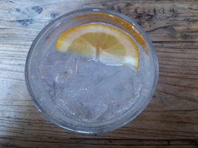 A close-up of a refreshing glass of lemonade with ice and lemon slices.