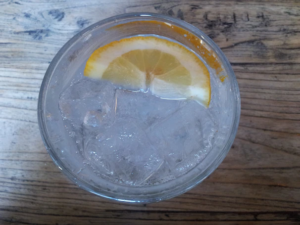 A close-up of a glass filled with freshly squeezed lemonade, condensation glistening on the outside.