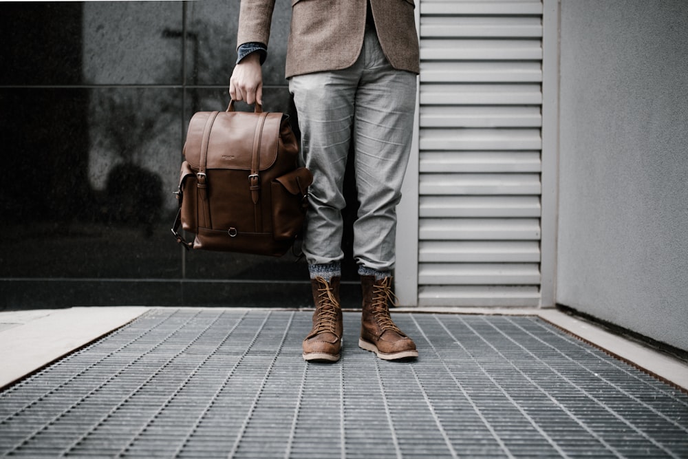 person holding brown leather bag