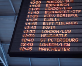 A low-angle shot of a departure board at an airport