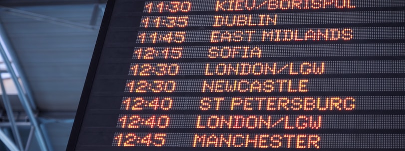 A low-angle shot of a departure board at an airport