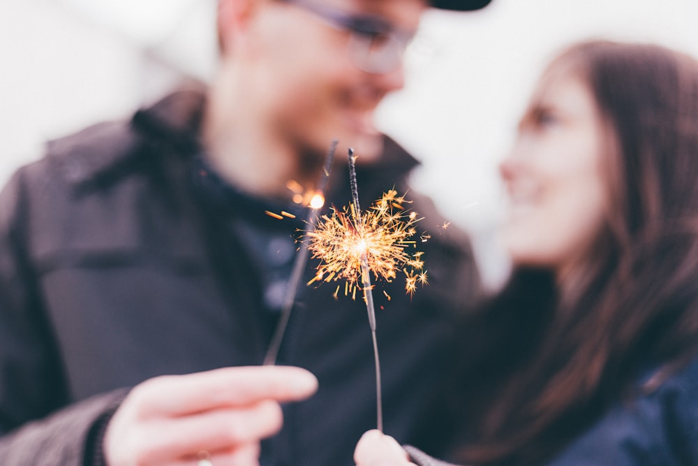 Homem e mulher segurando fogos de artifício