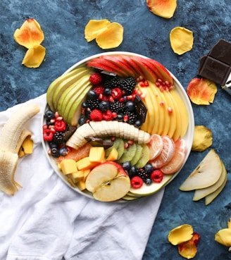 bowl of sliced fruits on white textile