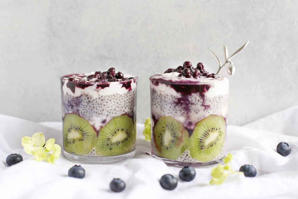 Cups of yogurt parfaits with fresh kiwi, chia seeds, and blueberries