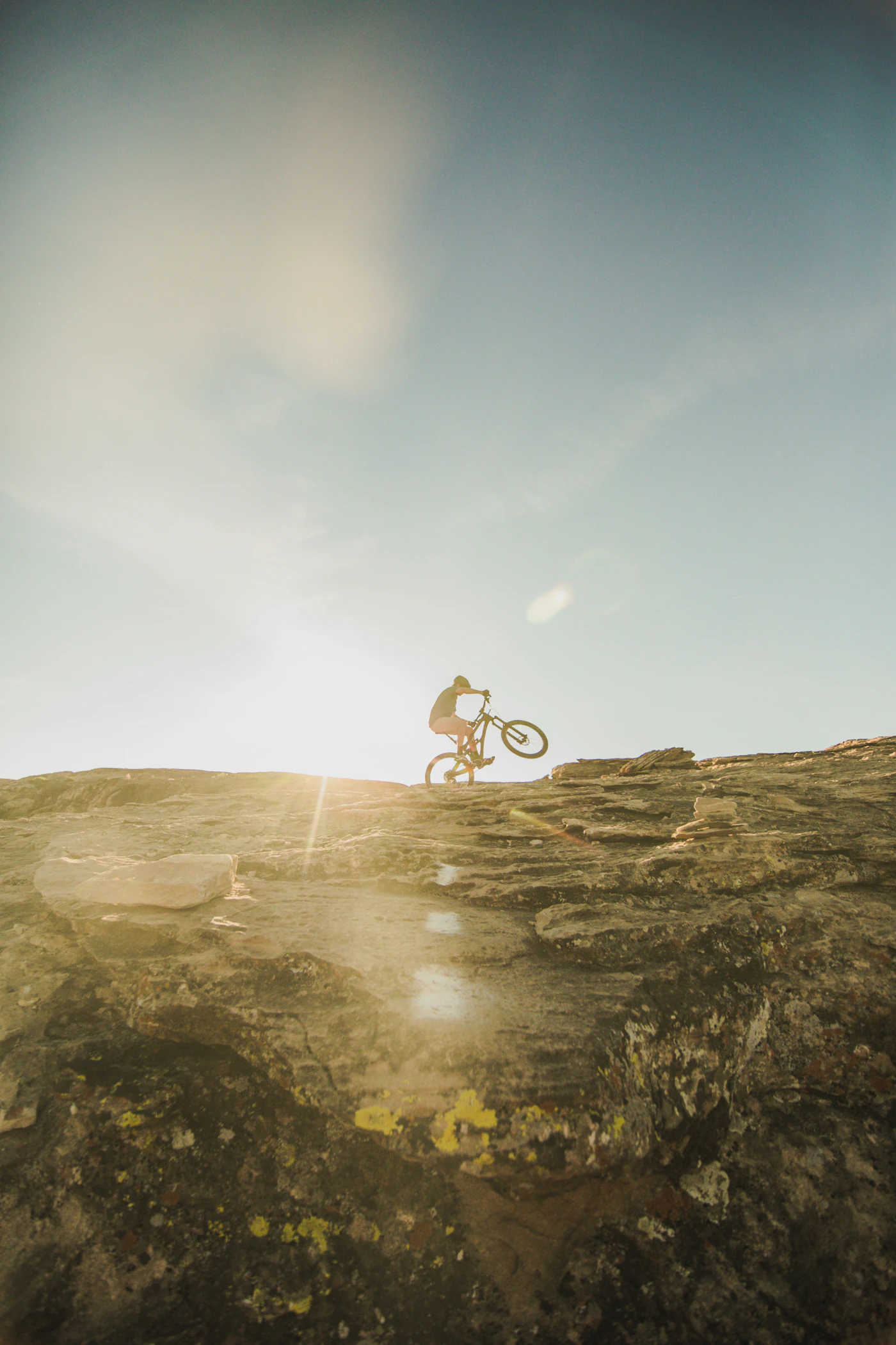A hazy mountain horizon with a lone rider on the road below