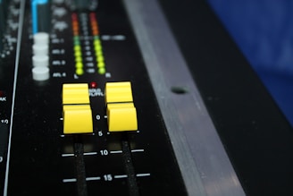 An audio mixing console with colorful faders and glowing meters.