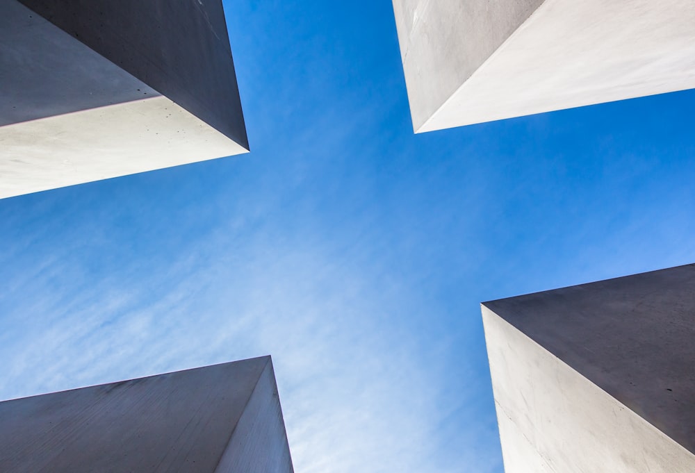 푸른 하늘 아래 콘크리트 건물의 로우 앵글 사진