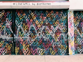 photo of black door shutter filled with heart murals