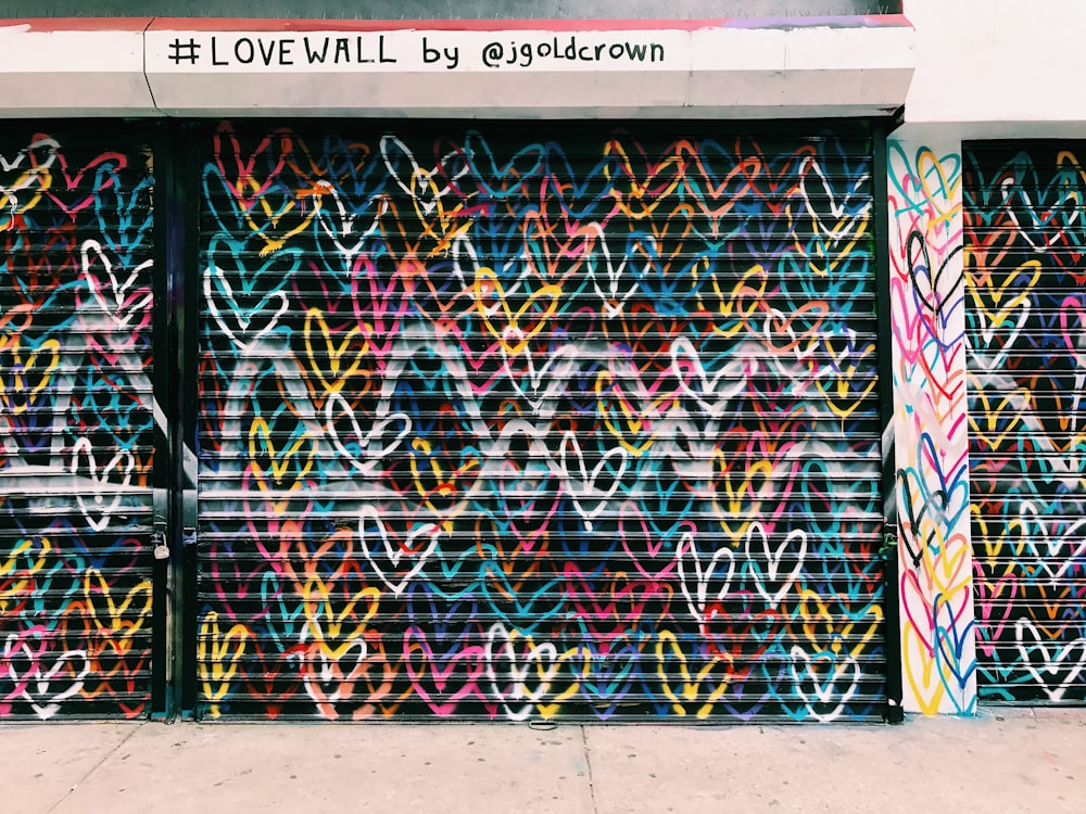 photo of black door shutter filled with heart murals