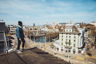 man standing on roof near buildings during daytime