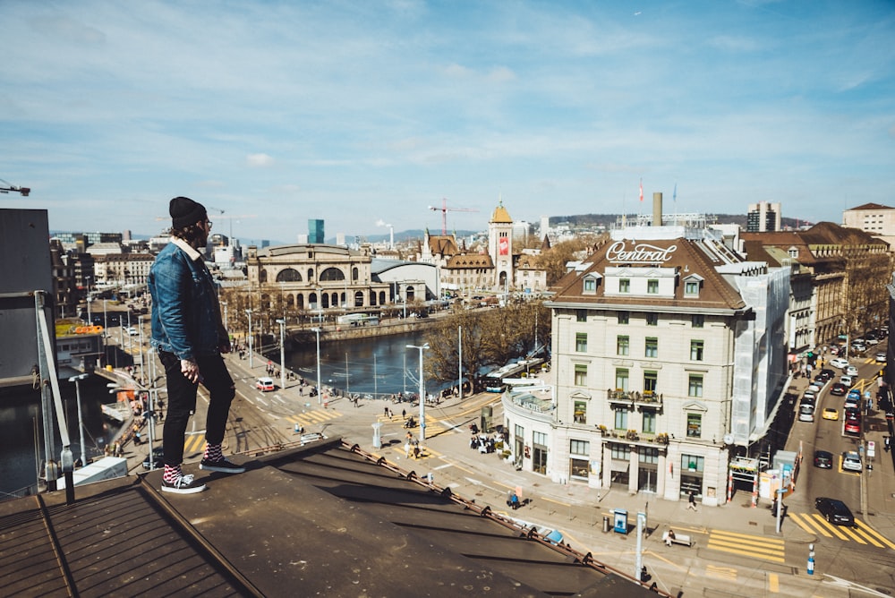 man standing on roof near buildings during daytime