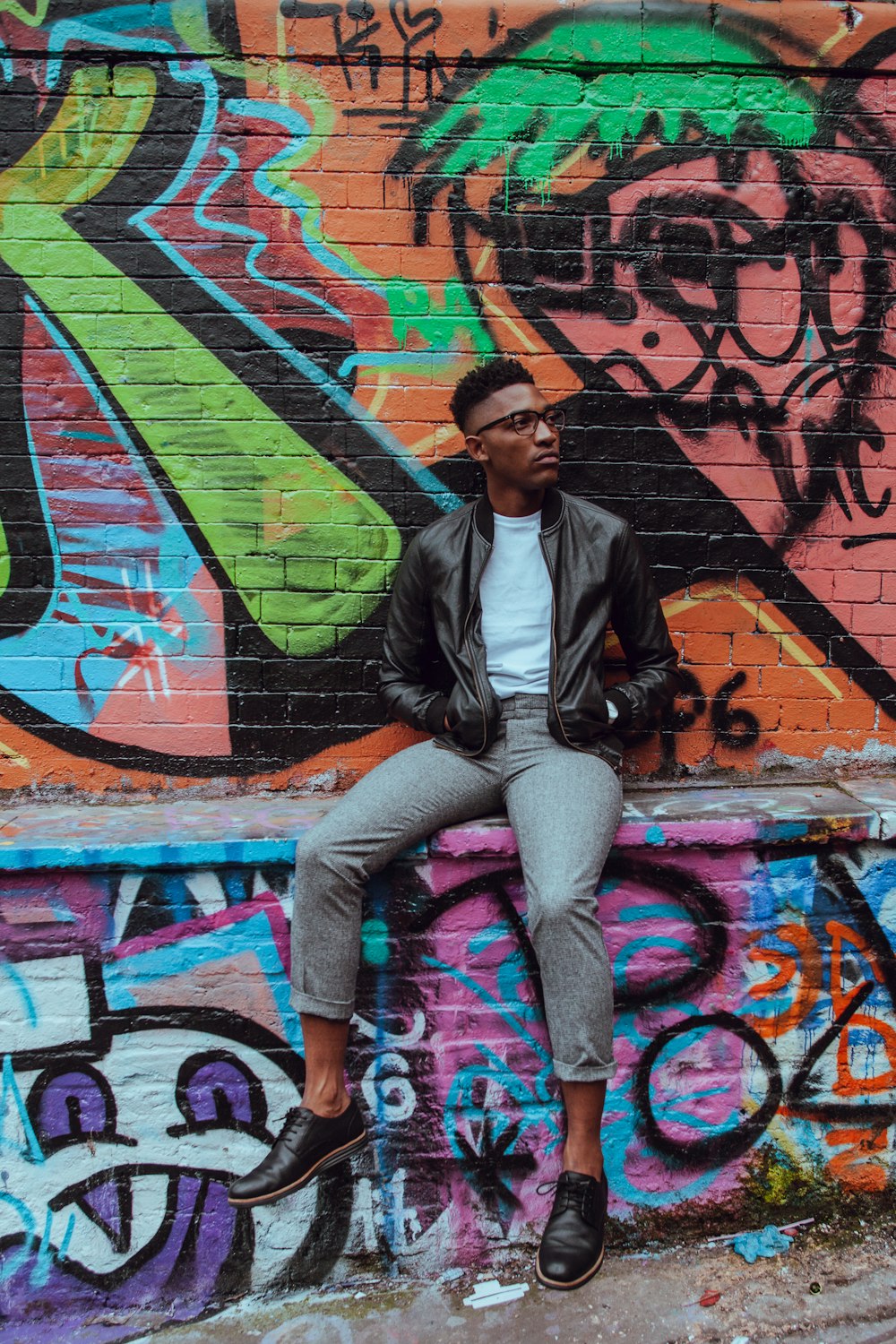 man sitting on concrete terrace with graffiti art