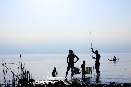 A group of friends enjoying a fishing trip by a lake.