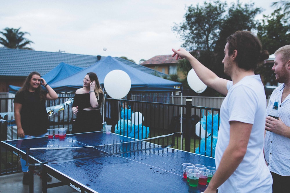 woman versus man playing beer pong under cloudy sky