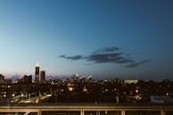 A city skyline at dusk with illuminated buildings and streets.