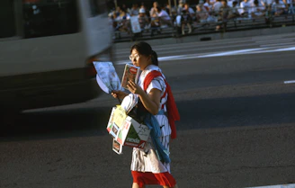 A person handing out colorful flyers on a busy city street.