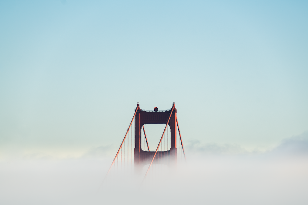 ponte de concreto vermelho cercada por nuvens
