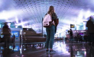 A vibrant image showing a traveler happily checking flight options on a tablet with a world map softly blurred in the background.