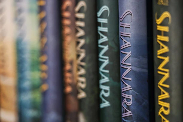 Several books are lined up vertically, with the spines displaying the word 'Shannara' in large letters. The spines are in different colors and textures, creating a visually appealing pattern.