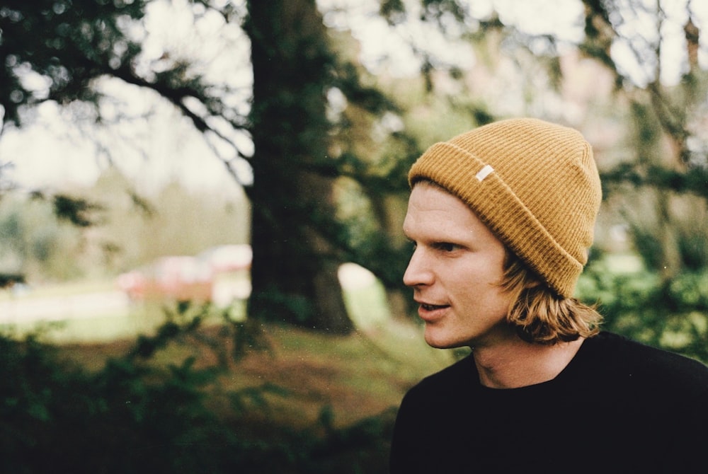 shadow depth of field photography of man in black shirt standing near trees