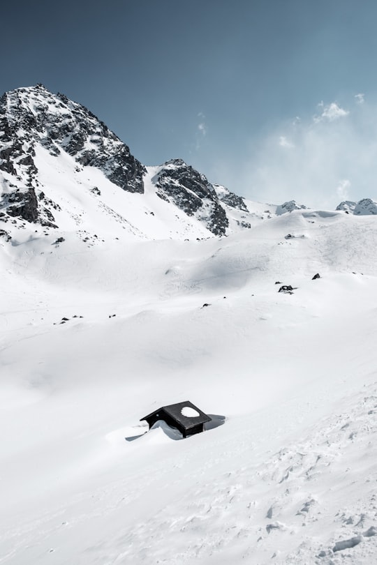 black house in middle of glacier mountain during daytime in Verbier Switzerland