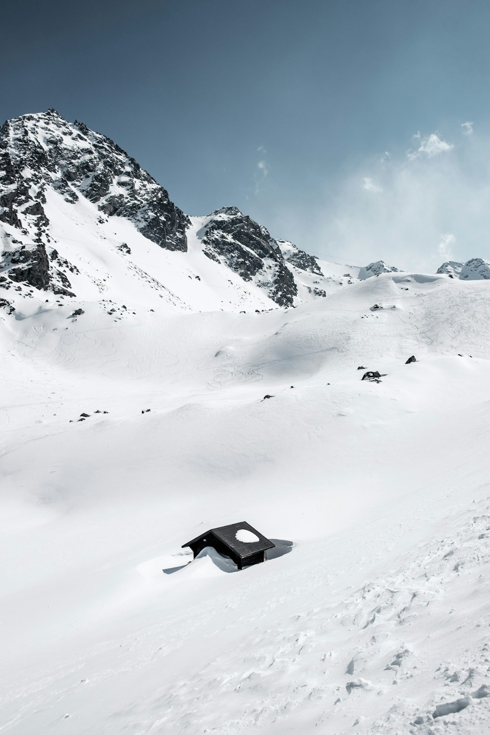 Casa negra en medio de la montaña glaciar durante el día