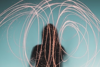 Silhouette of a figure immersed in swirling turquoise and violet light waves.