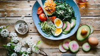 poached egg with vegetables and tomatoes on blue plate