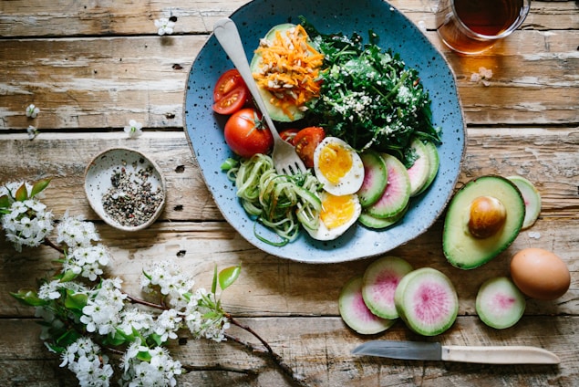 poached egg with vegetables and tomatoes on blue plate