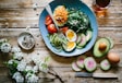poached egg with vegetables and tomatoes on blue plate