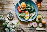 poached egg with vegetables and tomatoes on blue plate