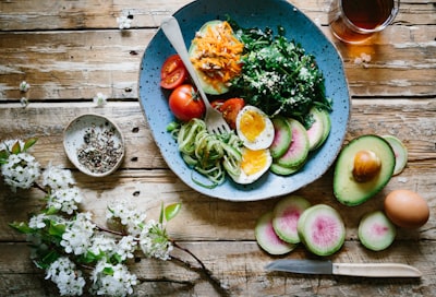 poached egg with vegetables and tomatoes on blue plate eat zoom background