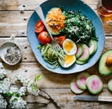 poached egg with vegetables and tomatoes on blue plate