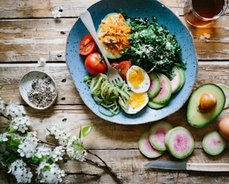 poached egg with vegetables and tomatoes on blue plate