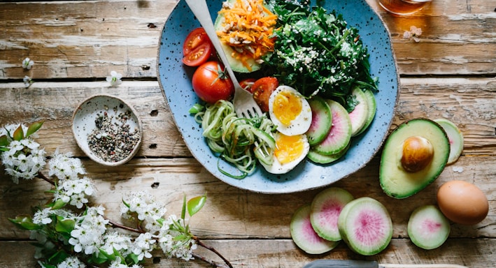 poached egg with vegetables and tomatoes on blue plate