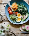 poached egg with vegetables and tomatoes on blue plate