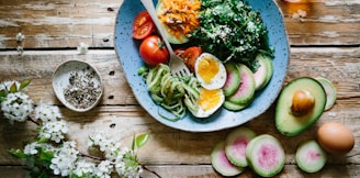 poached egg with vegetables and tomatoes on blue plate