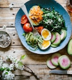 poached egg with vegetables and tomatoes on blue plate