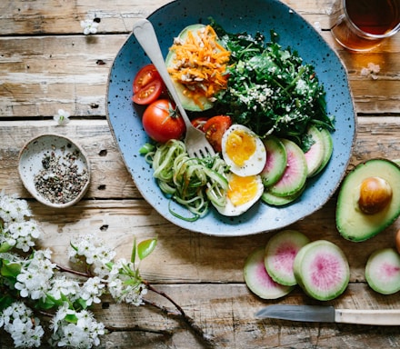 poached egg with vegetables and tomatoes on blue plate