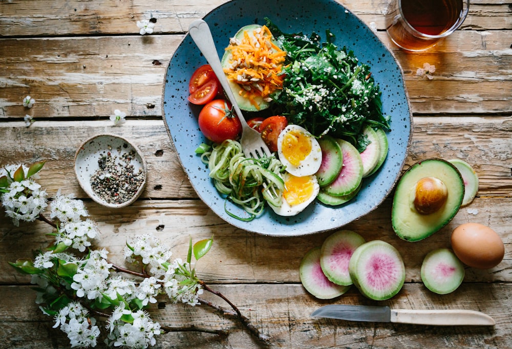 Oeuf poché aux légumes et tomates sur assiette bleue