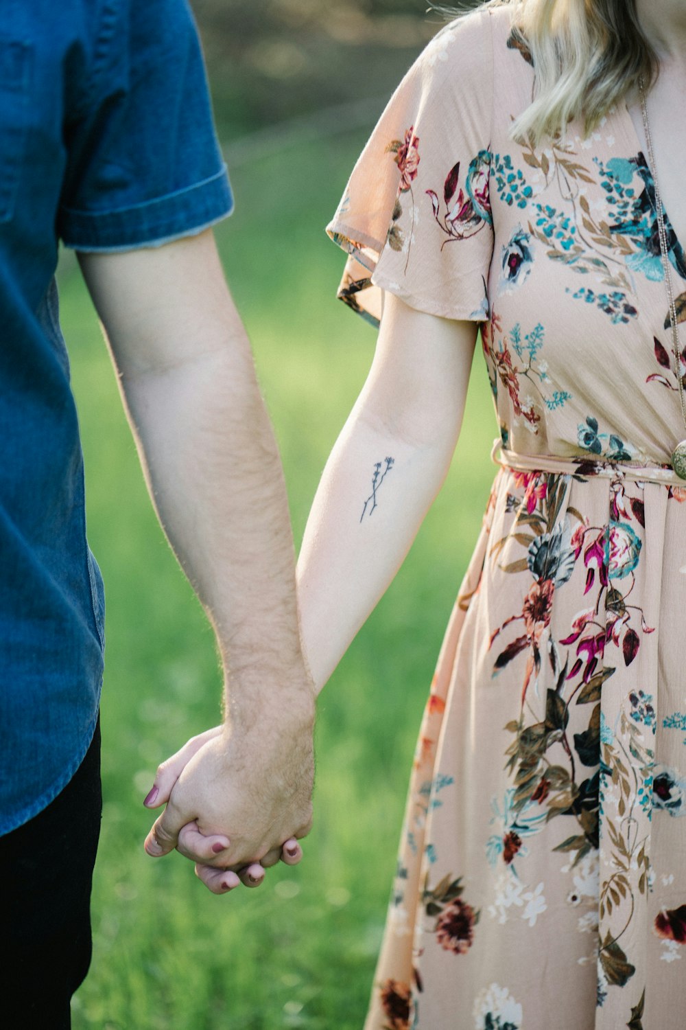 Fotografía de enfoque selectivo de hombre y mujer tomados de la mano