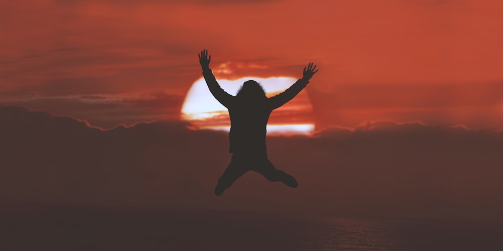 silhouette of person doing jumpshot during sunset